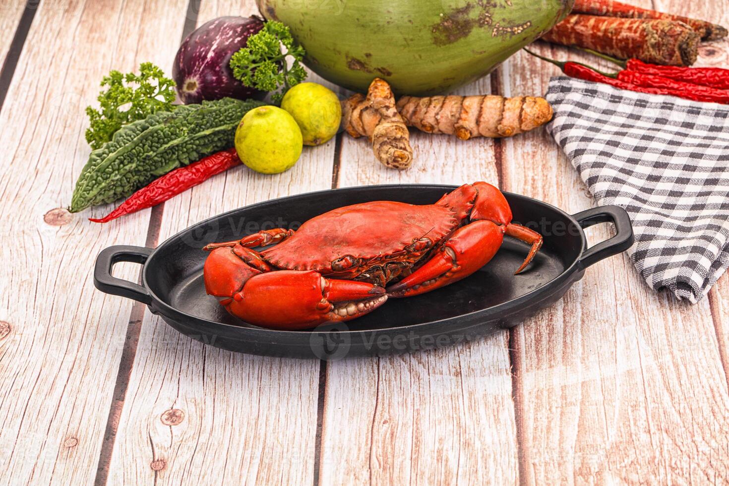 A crab in a pan on a wooden table photo