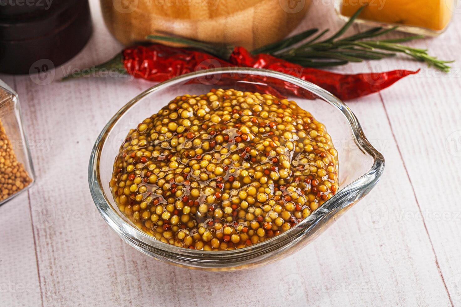 A bowl of mustard and spices on a table photo