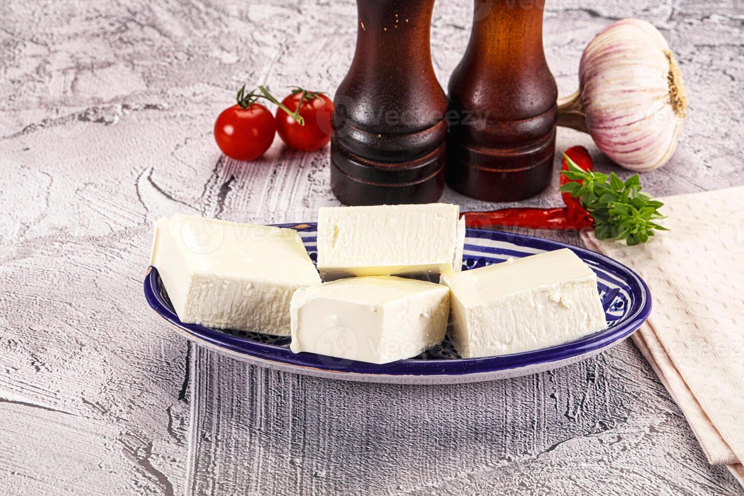 A plate of cheese, tomatoes, garlic and a bottle of ketchup photo