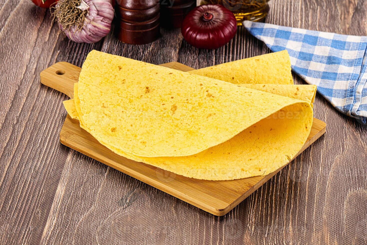 A cutting board with some tortillas and other ingredients photo