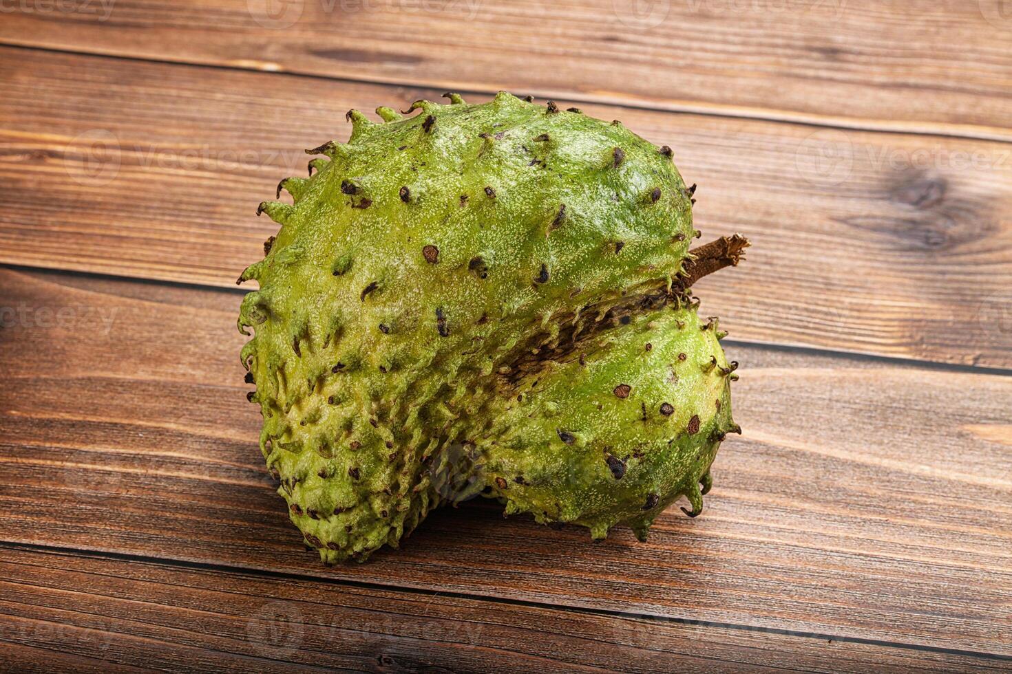 A single green fruit on a wooden table photo