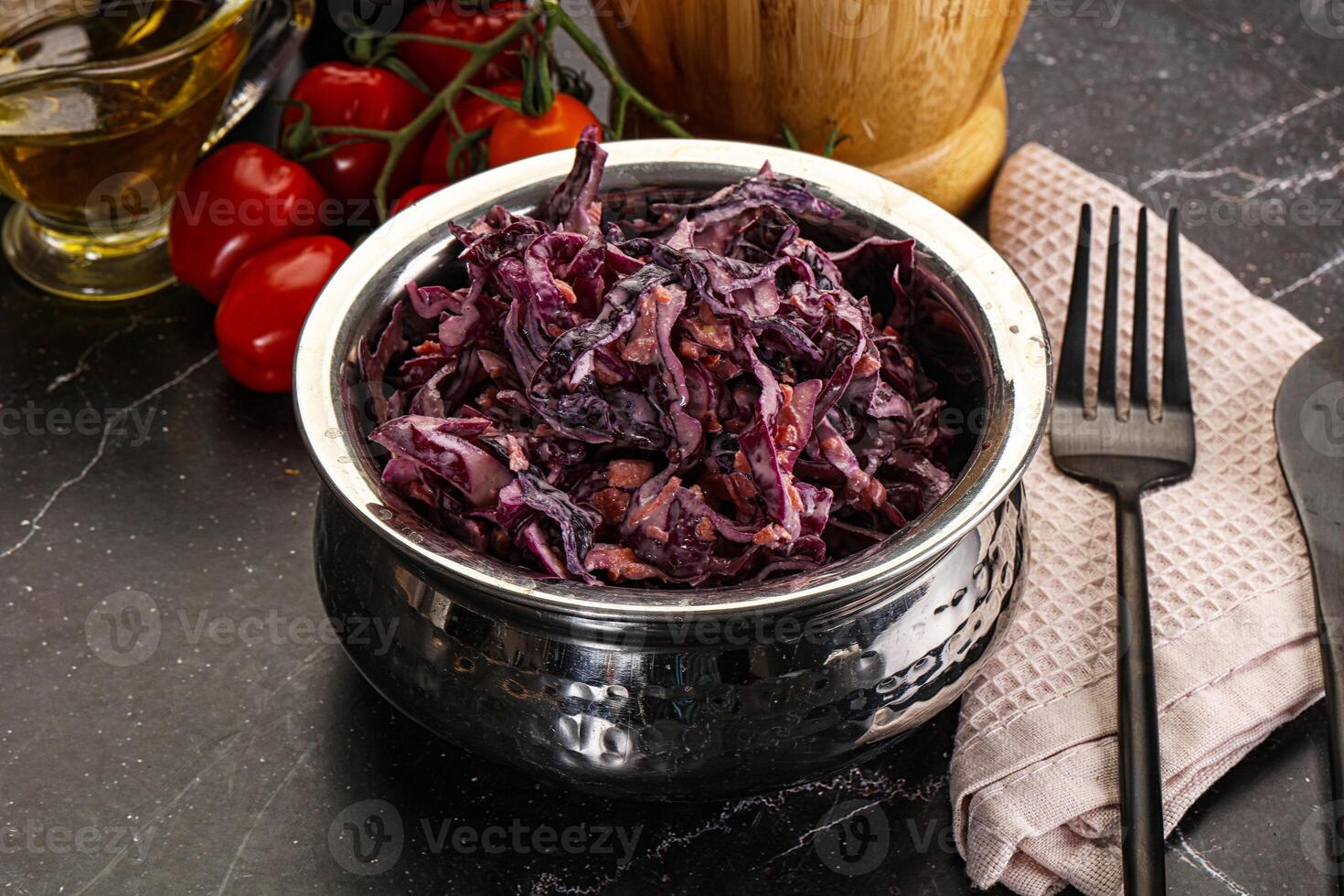A bowl of red cabbage with a fork and knife photo