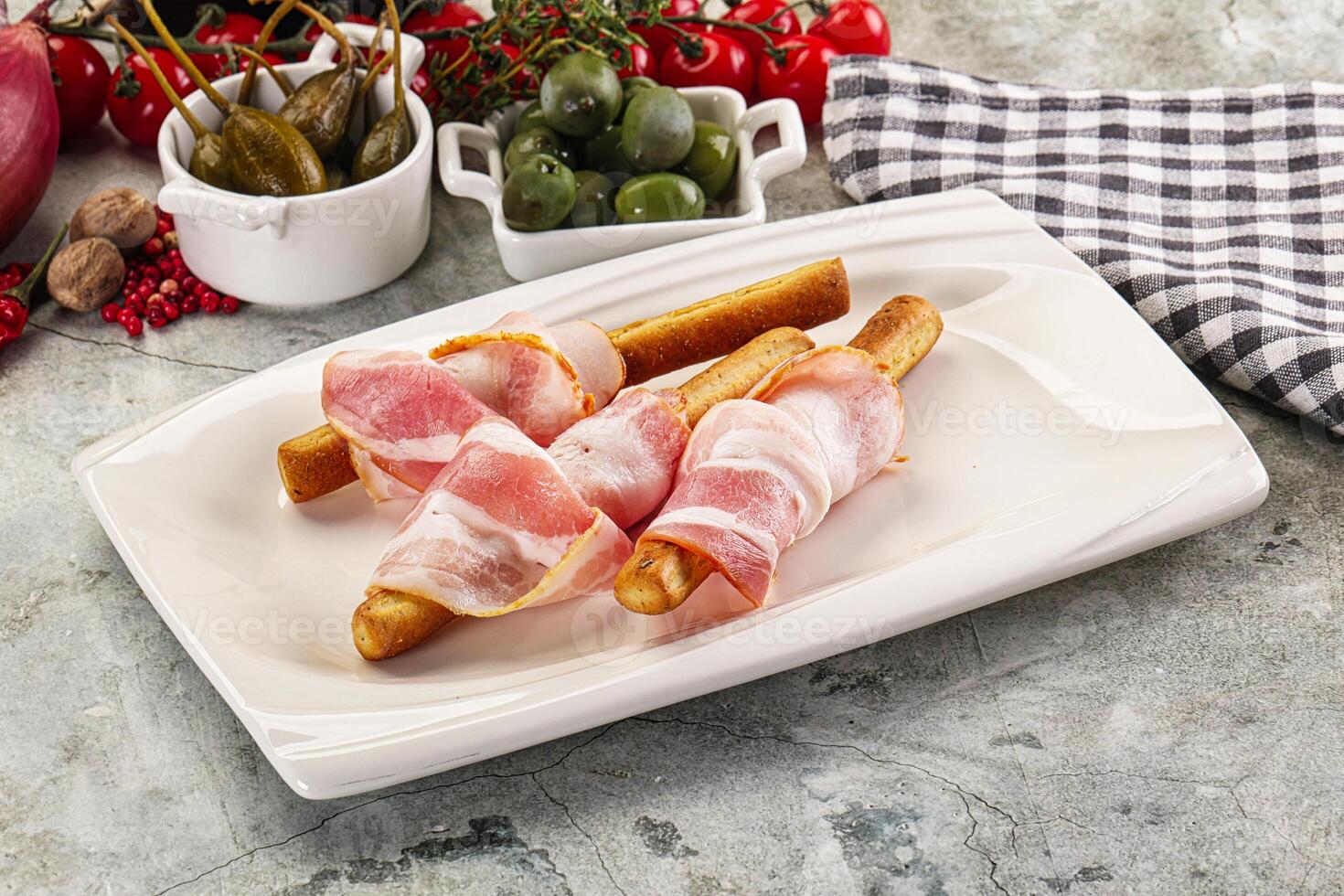 A plate with bacon wrapped french fries and a bowl of olives photo