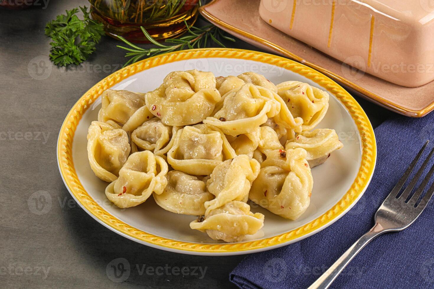 A plate of pasta with a fork and a bottle of wine photo