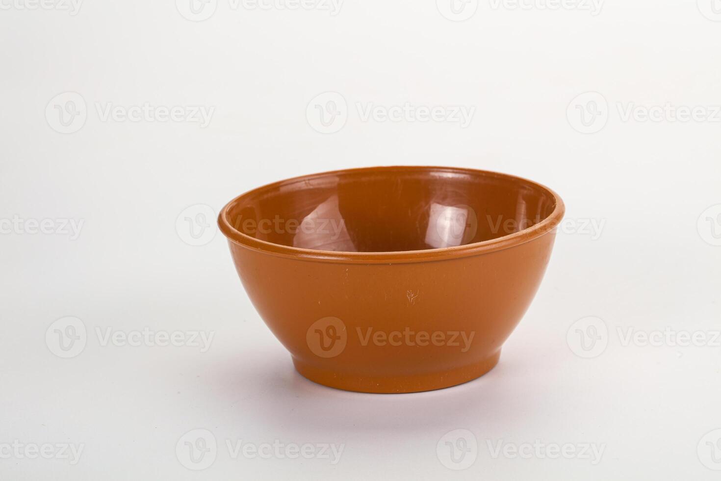 A small brown bowl on a white surface photo