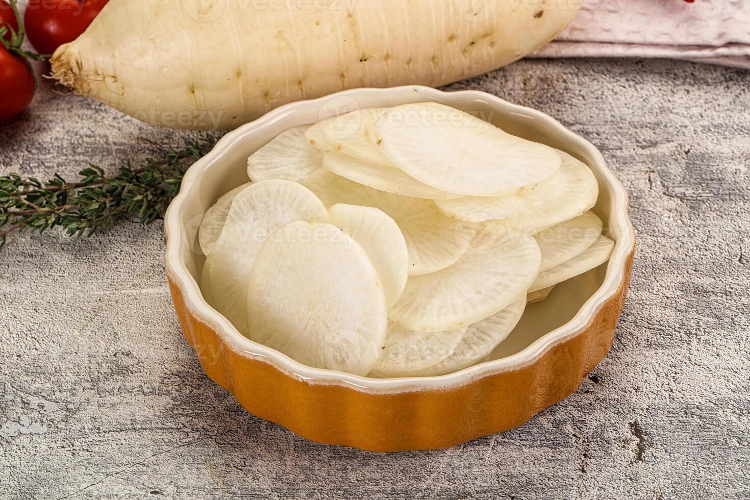 A bowl filled with sliced potatoes and tomatoes photo