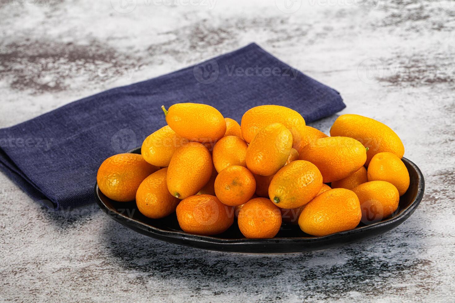 A bowl of oranges and a napkin on a table photo