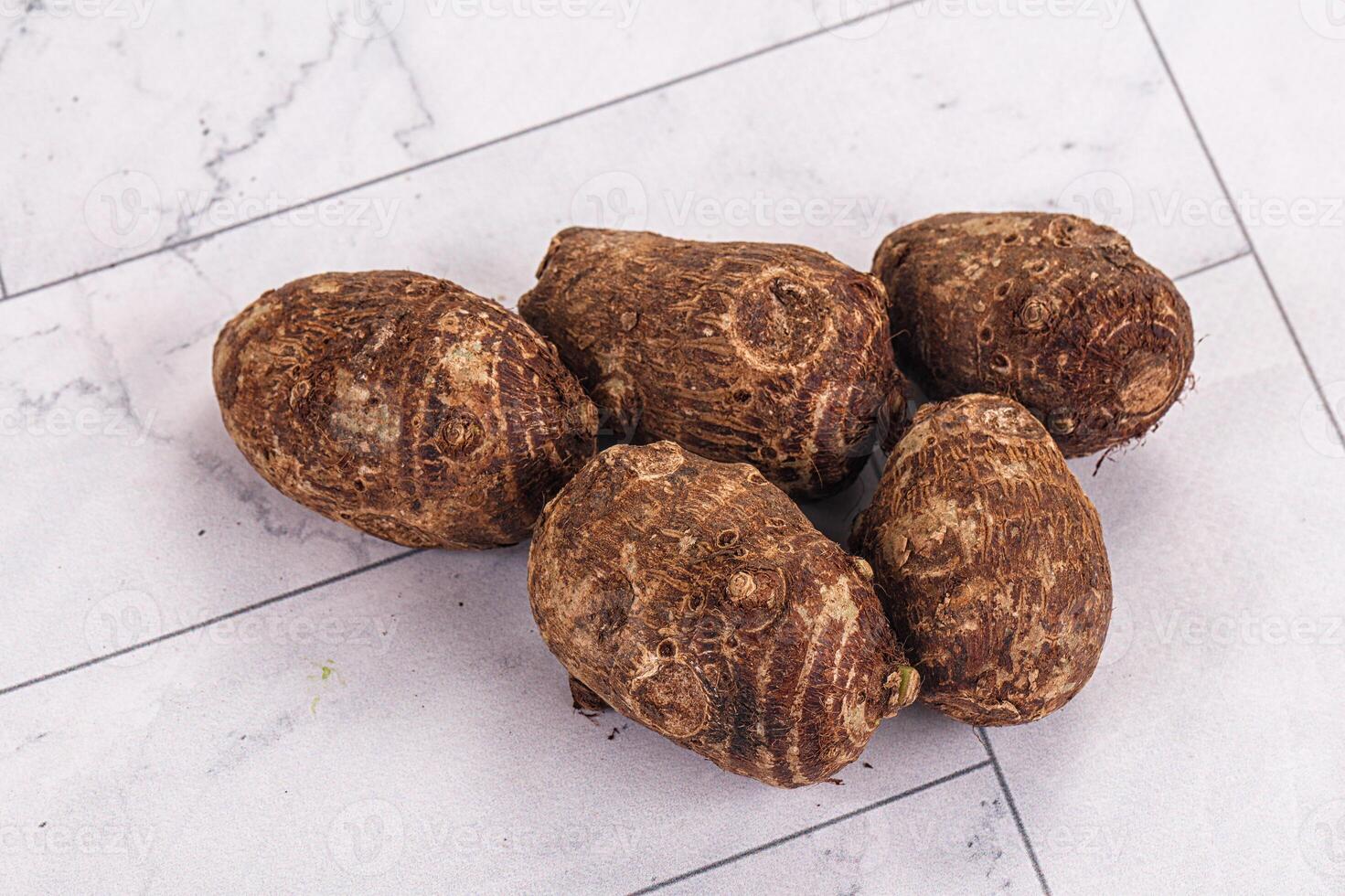 A group of potatoes on a white surface photo