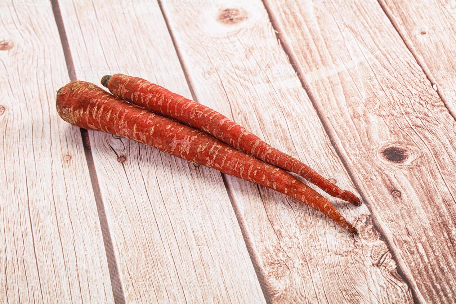 Two carrots on a wooden surface photo