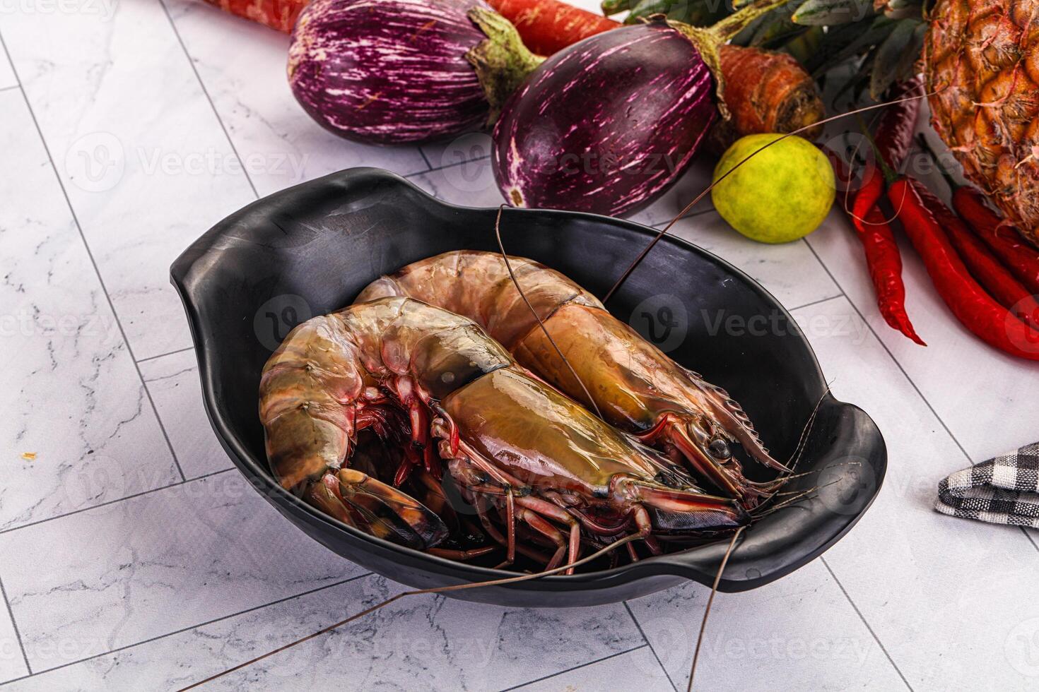 A bowl of shrimp and vegetables on a table photo