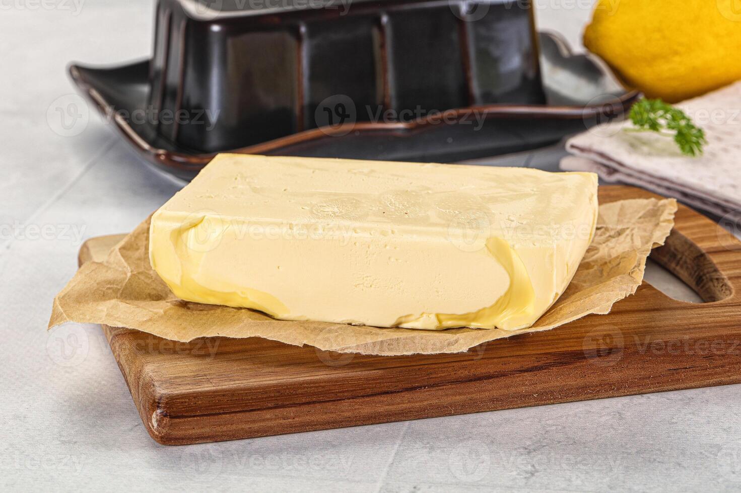 A block of butter sitting on a cutting board photo