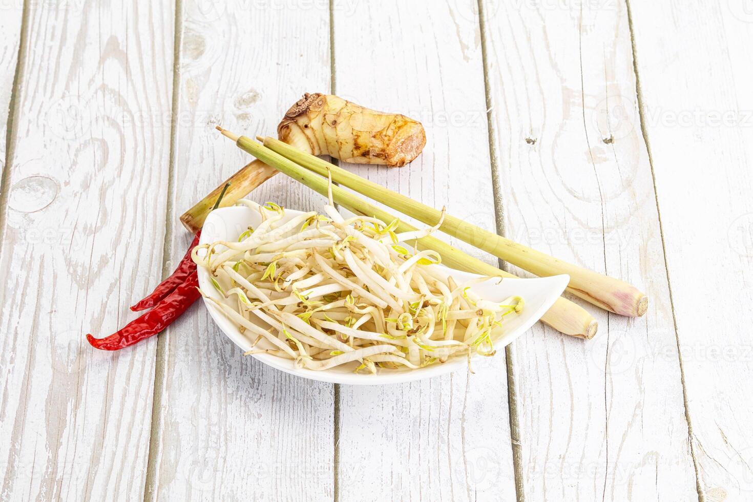 A bowl of noodles and other ingredients on a white table photo