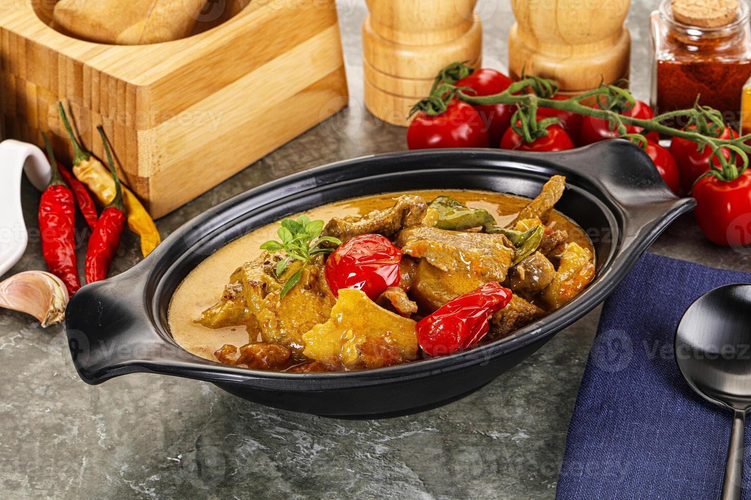 A bowl of food with vegetables and spices on a table photo