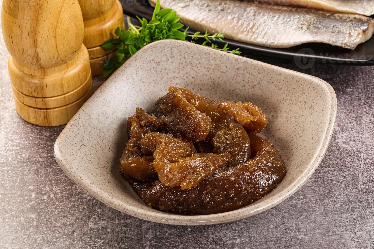 A bowl of food with a knife and a wooden spoon photo