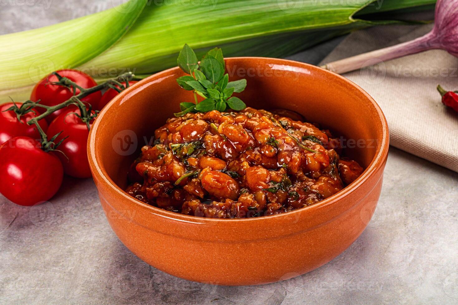 A bowl of chili with tomatoes and onions photo