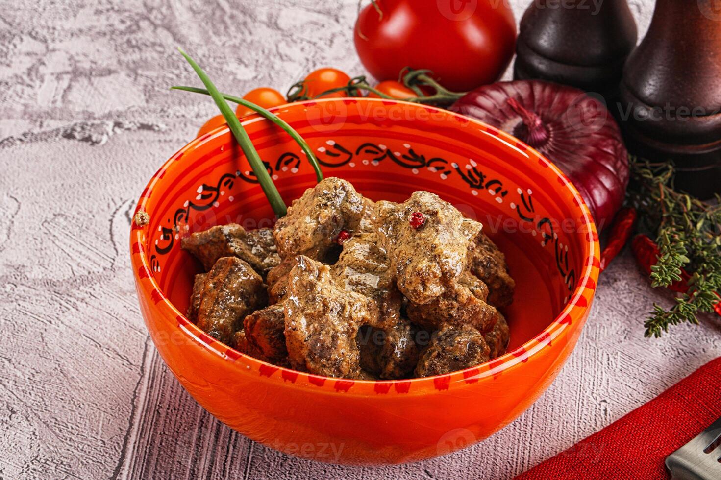 A bowl of meat and vegetables on a table photo