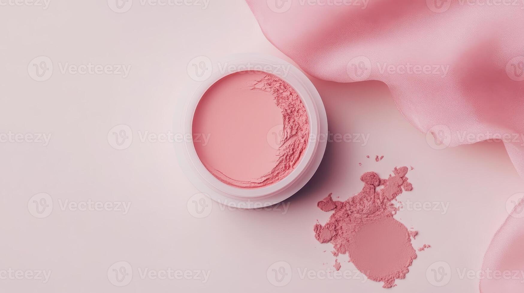 Beautiful pink cream blush in a white container on a light background with scattered pink powder nearby photo