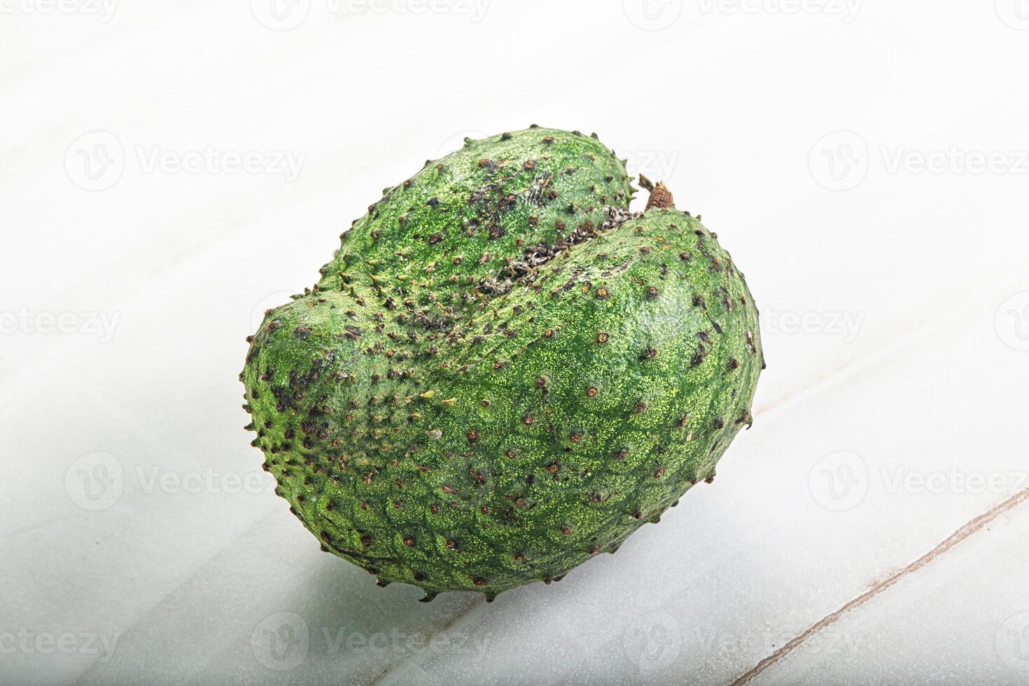 A green fruit with a white background photo