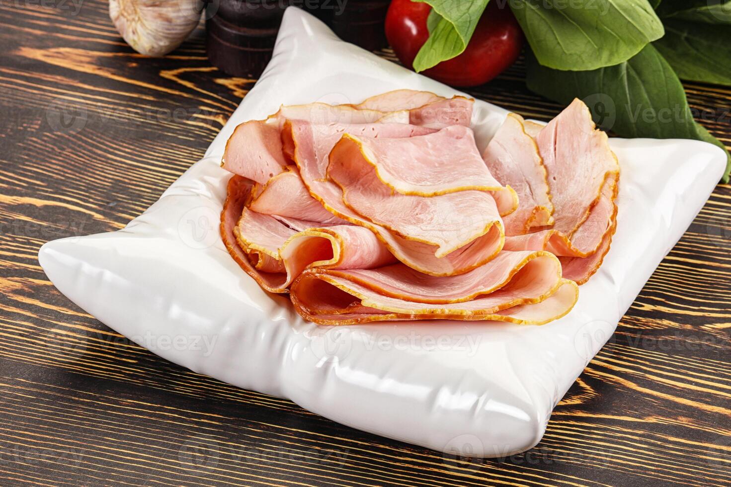 A white plate with ham slices on it photo