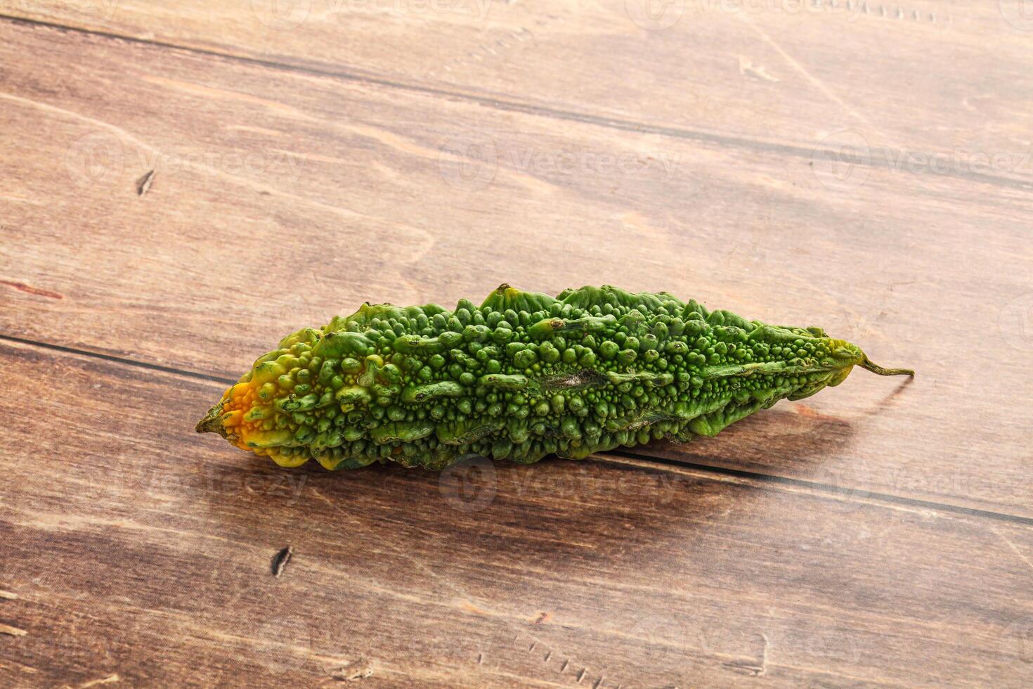 A green cucumber on a wooden table photo