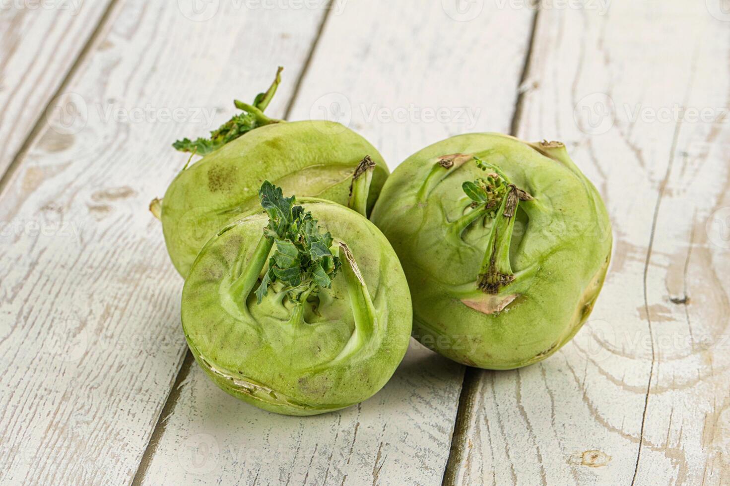 Three green fruits sitting on a white table photo