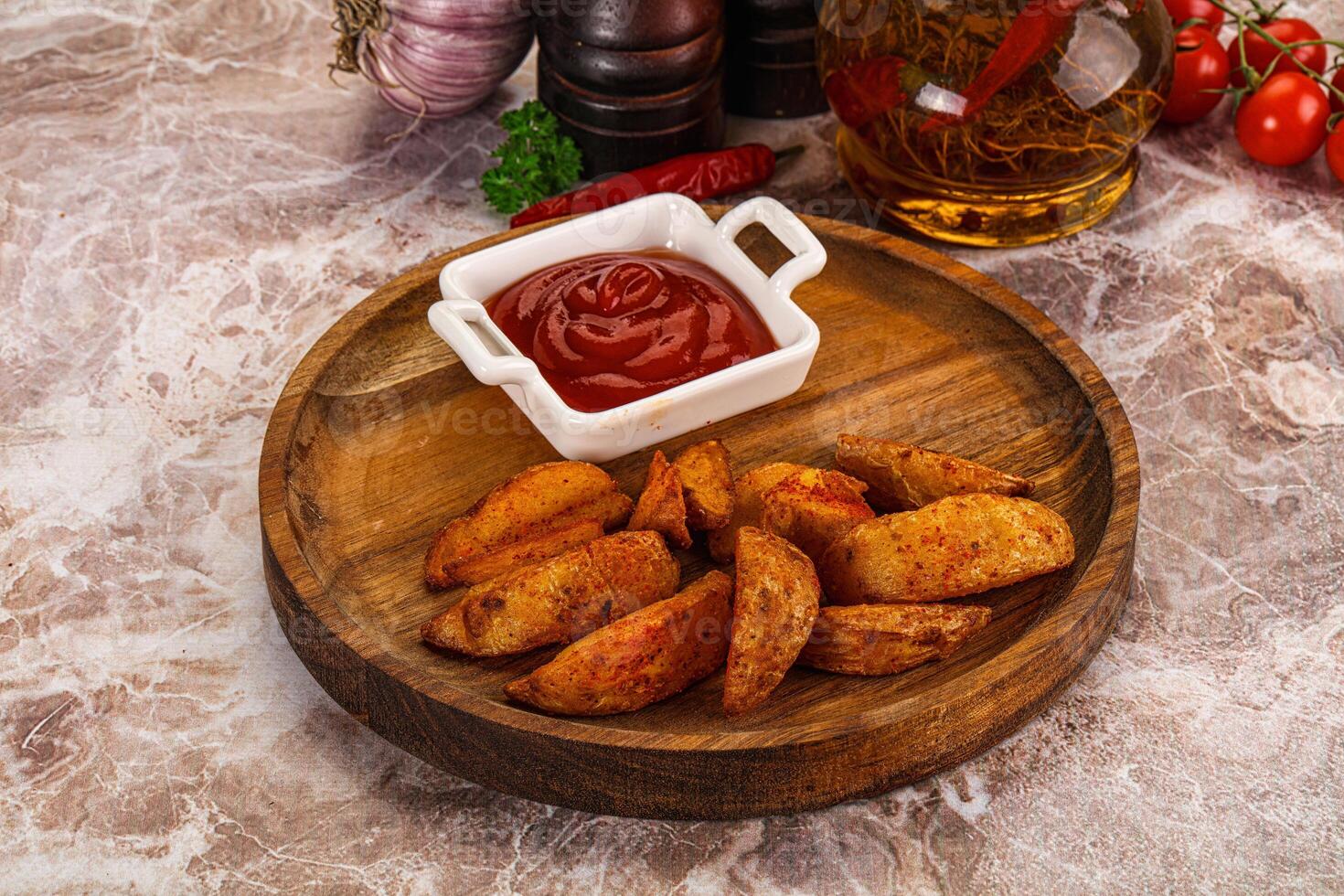 A plate with some potatoes and ketchup on it photo