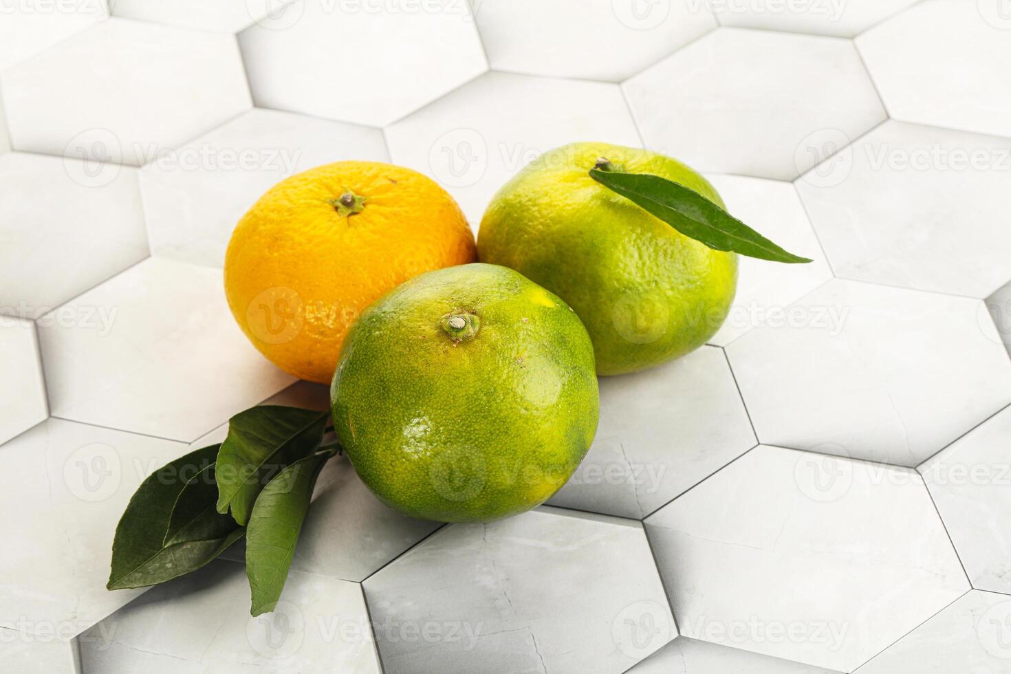 Three oranges and an orange on a white tile photo