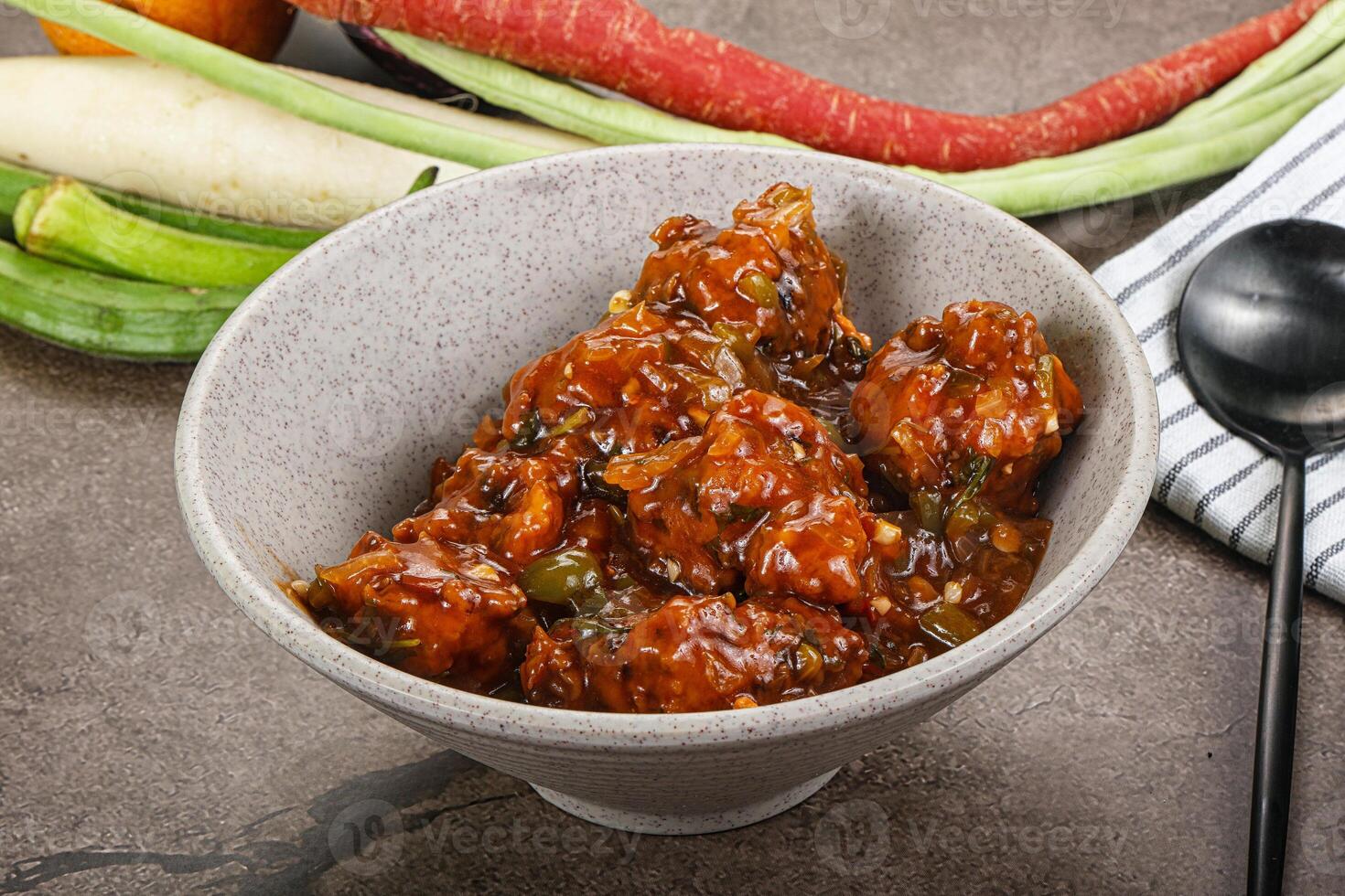 A bowl of food with vegetables and a spoon photo