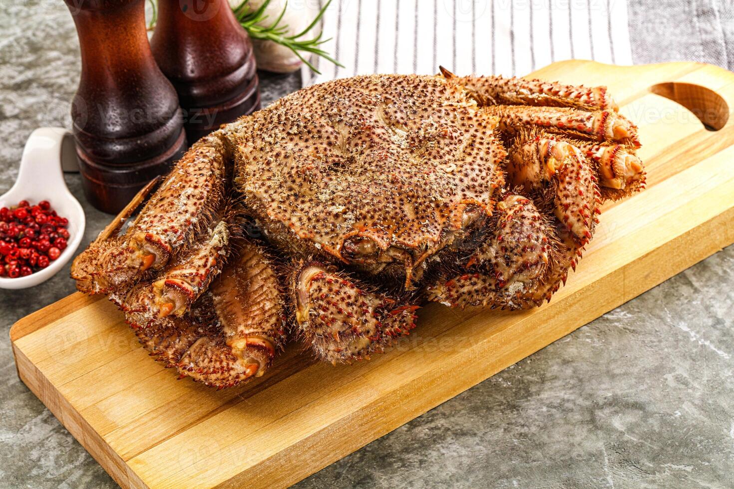 A large crab sitting on a cutting board photo