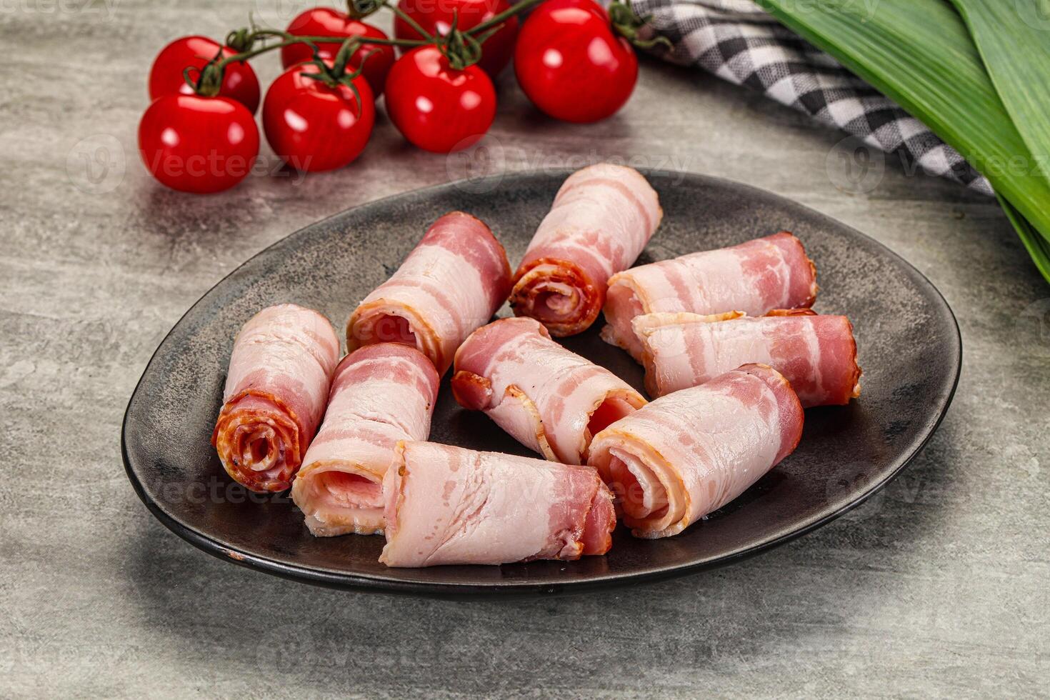Bacon wrapped in ham on a plate with tomatoes photo