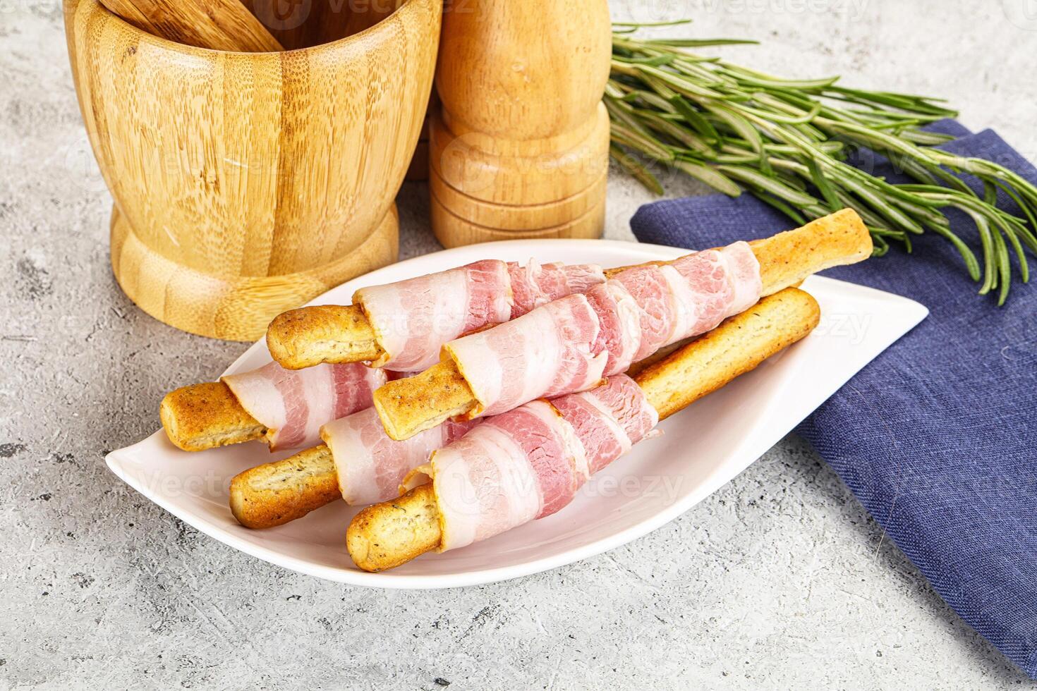 Bacon wrapped bread sticks on a plate photo