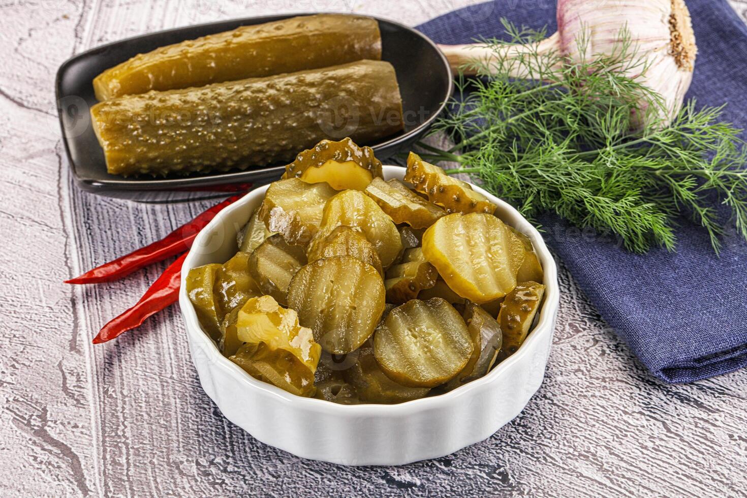A bowl of pickles and a bowl of pickles photo