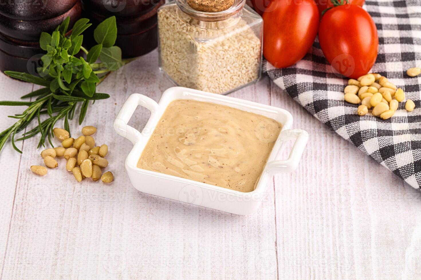 A bowl of sauce with tomatoes, nuts and other ingredients photo