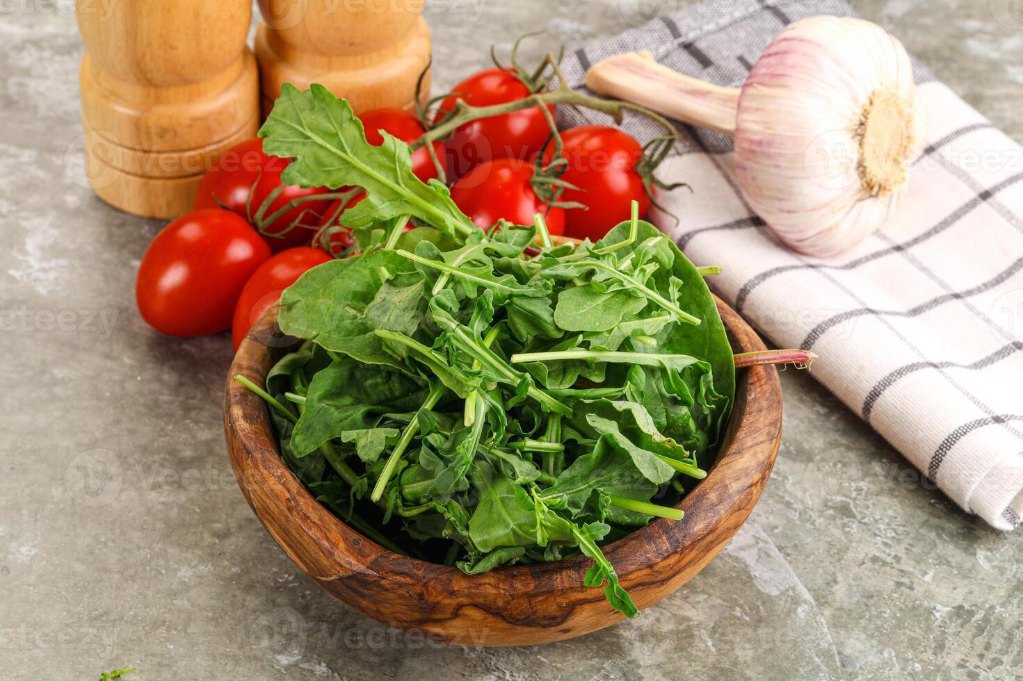 Fresh spinach, tomatoes and garlic on a wooden bowl photo