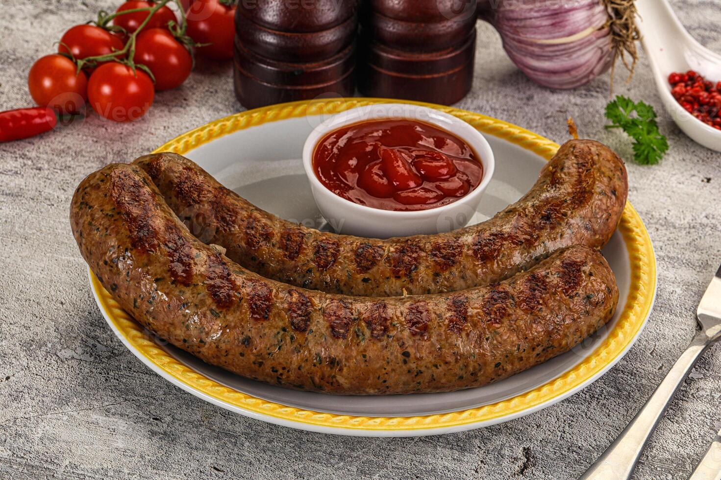 Two sausages on a plate with ketchup and tomatoes photo