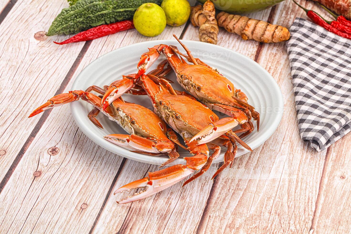 A bowl of crabs on a table with other vegetables photo
