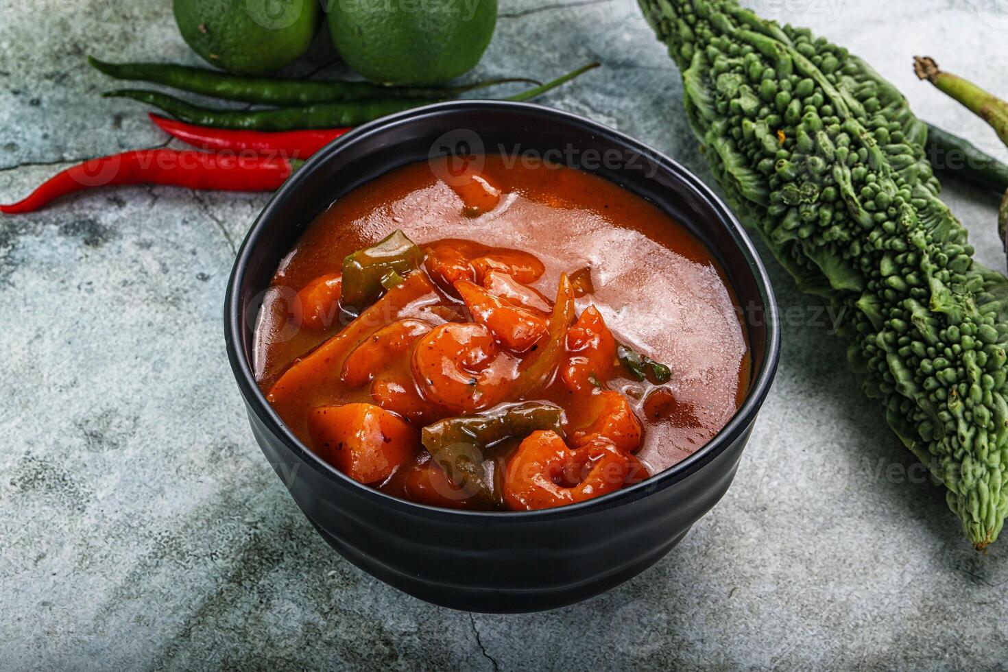 A bowl of chili and vegetables on a table photo