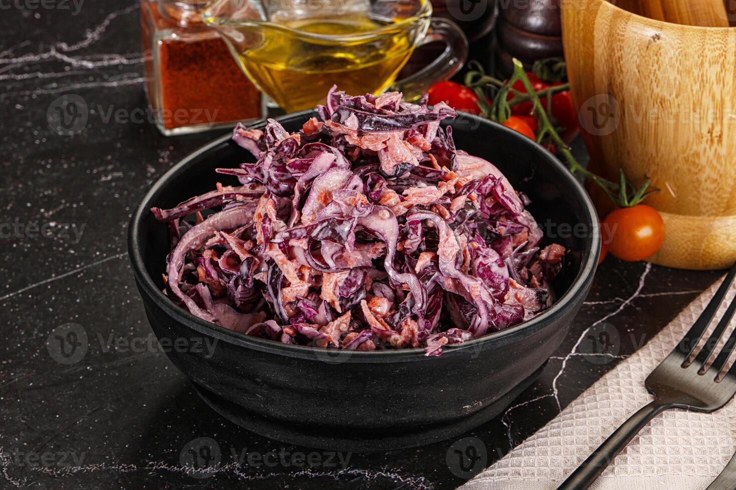 A bowl of red cabbage salad with a fork and knife photo