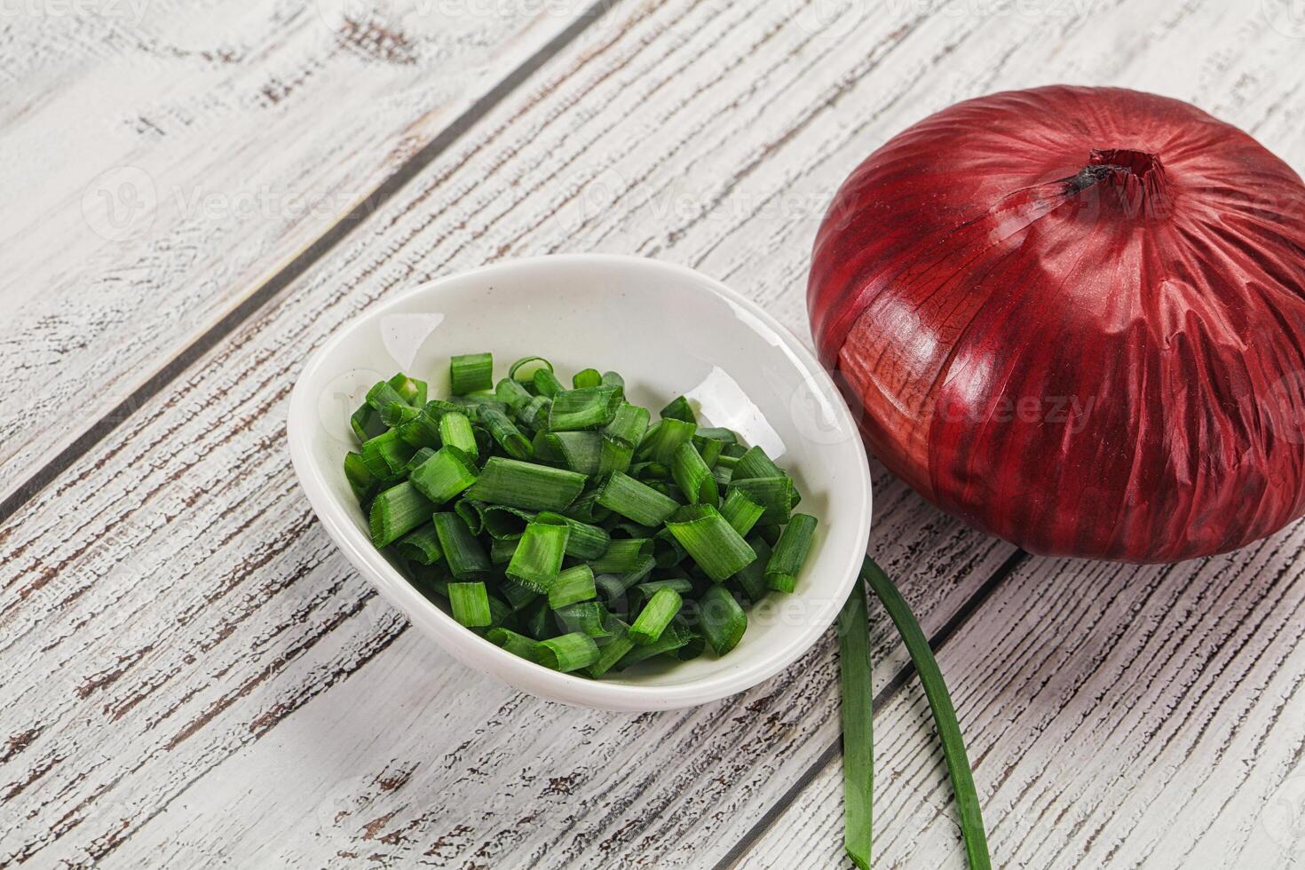 A bowl of chopped onions and a red onion photo