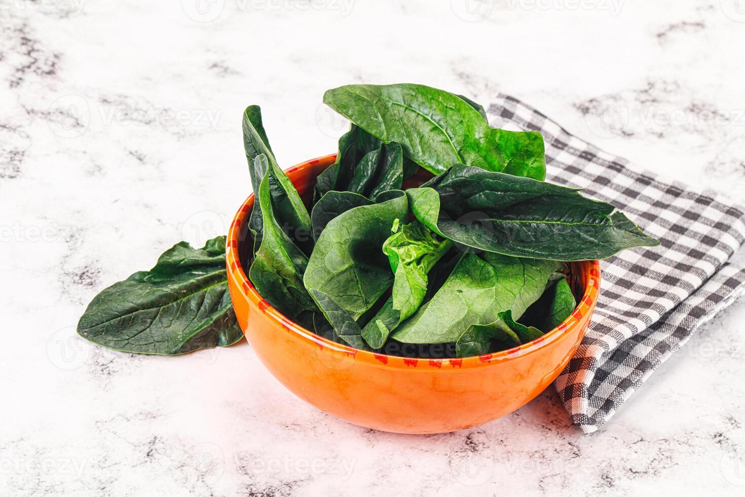 A bowl of spinach on a table photo