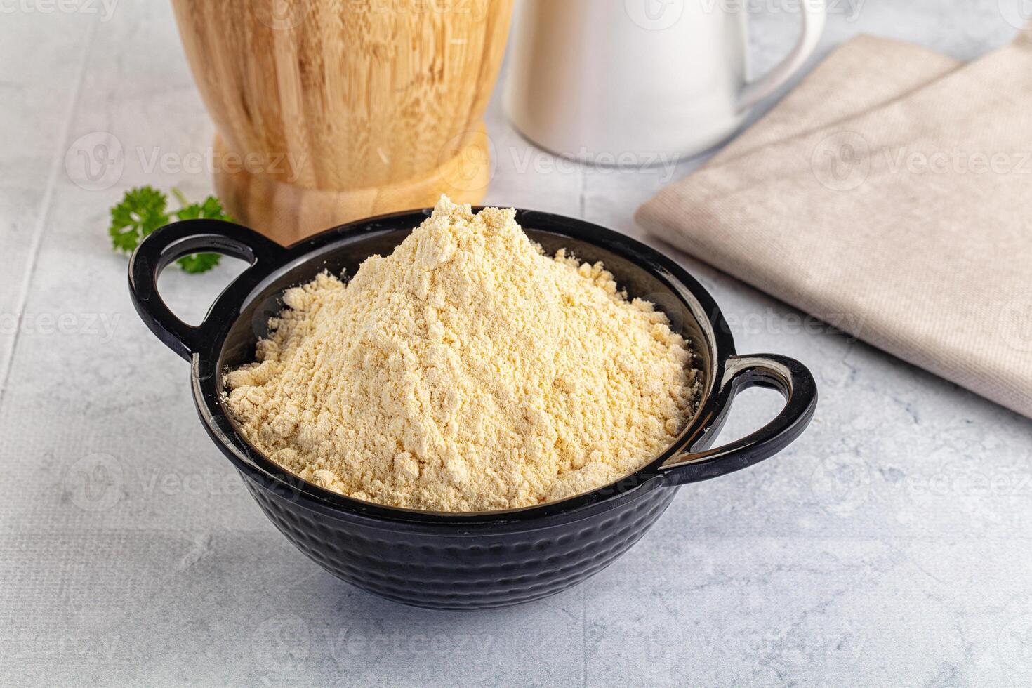 A bowl of flour next to a wooden spoon photo