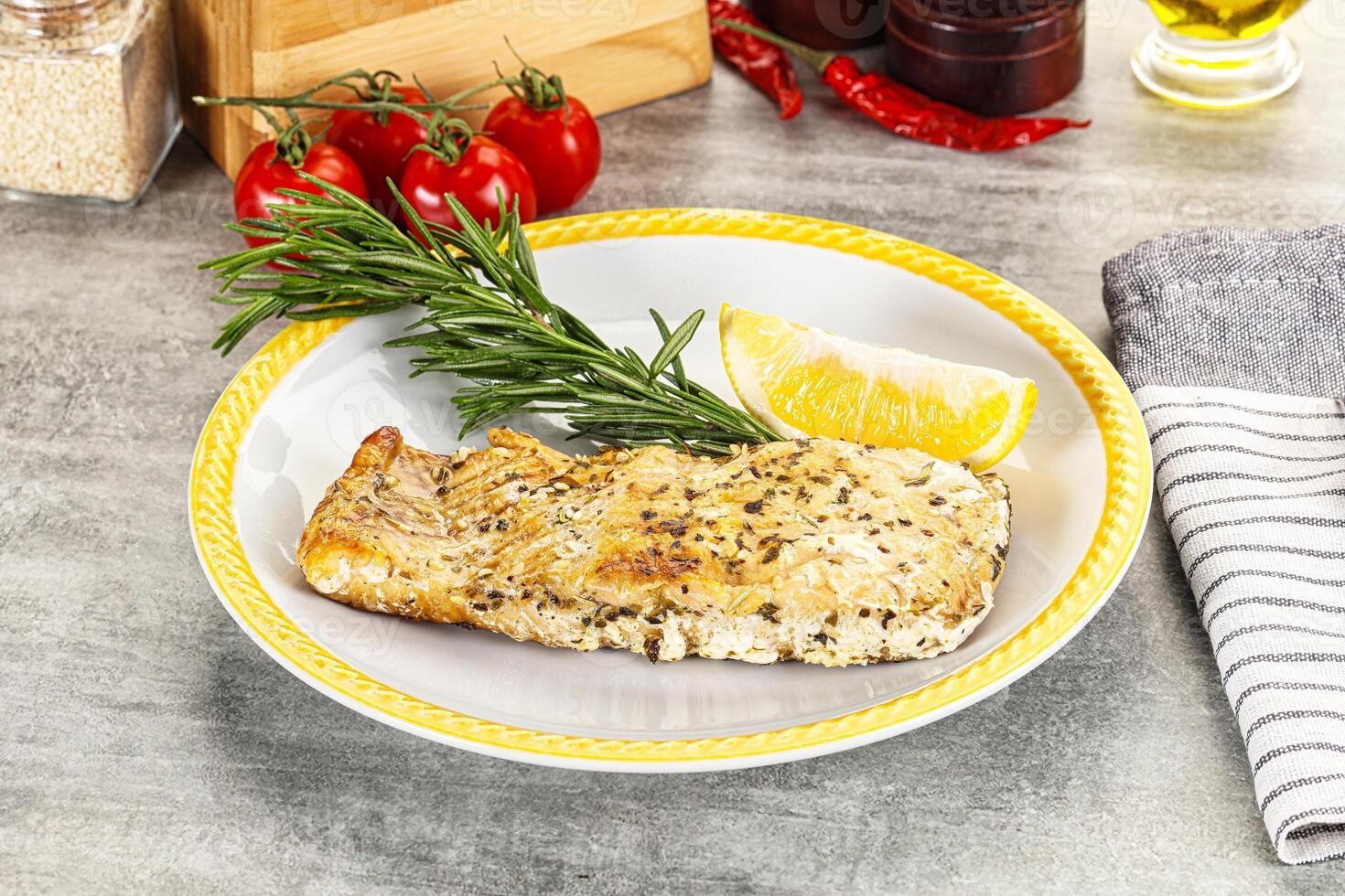 A plate of food with a lemon and a rosemary sprig photo