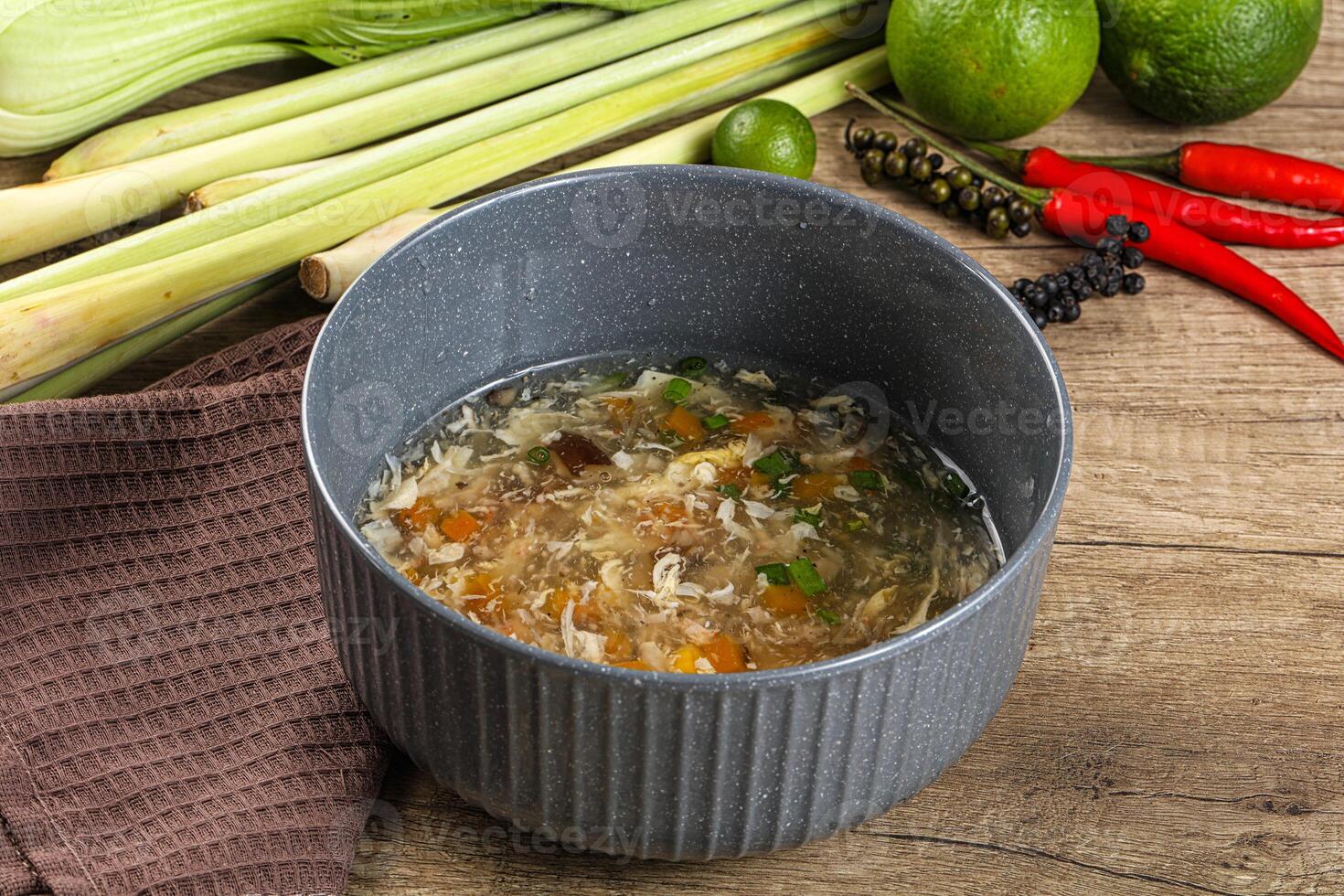 A bowl of soup with a spoon and some vegetables photo