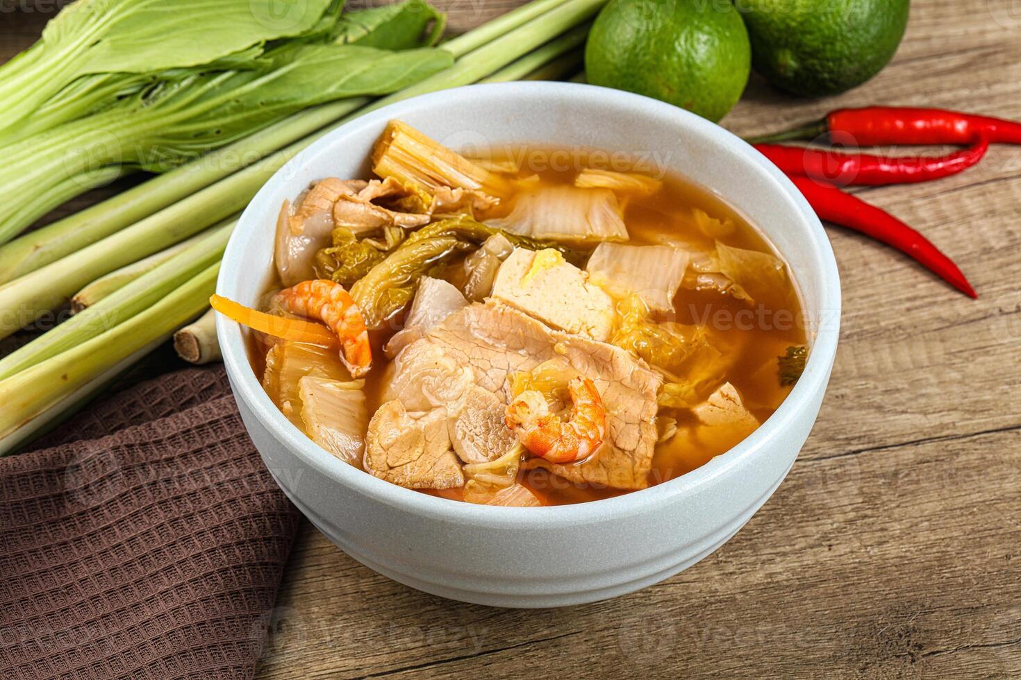 A bowl of soup with meat, vegetables and other ingredients photo
