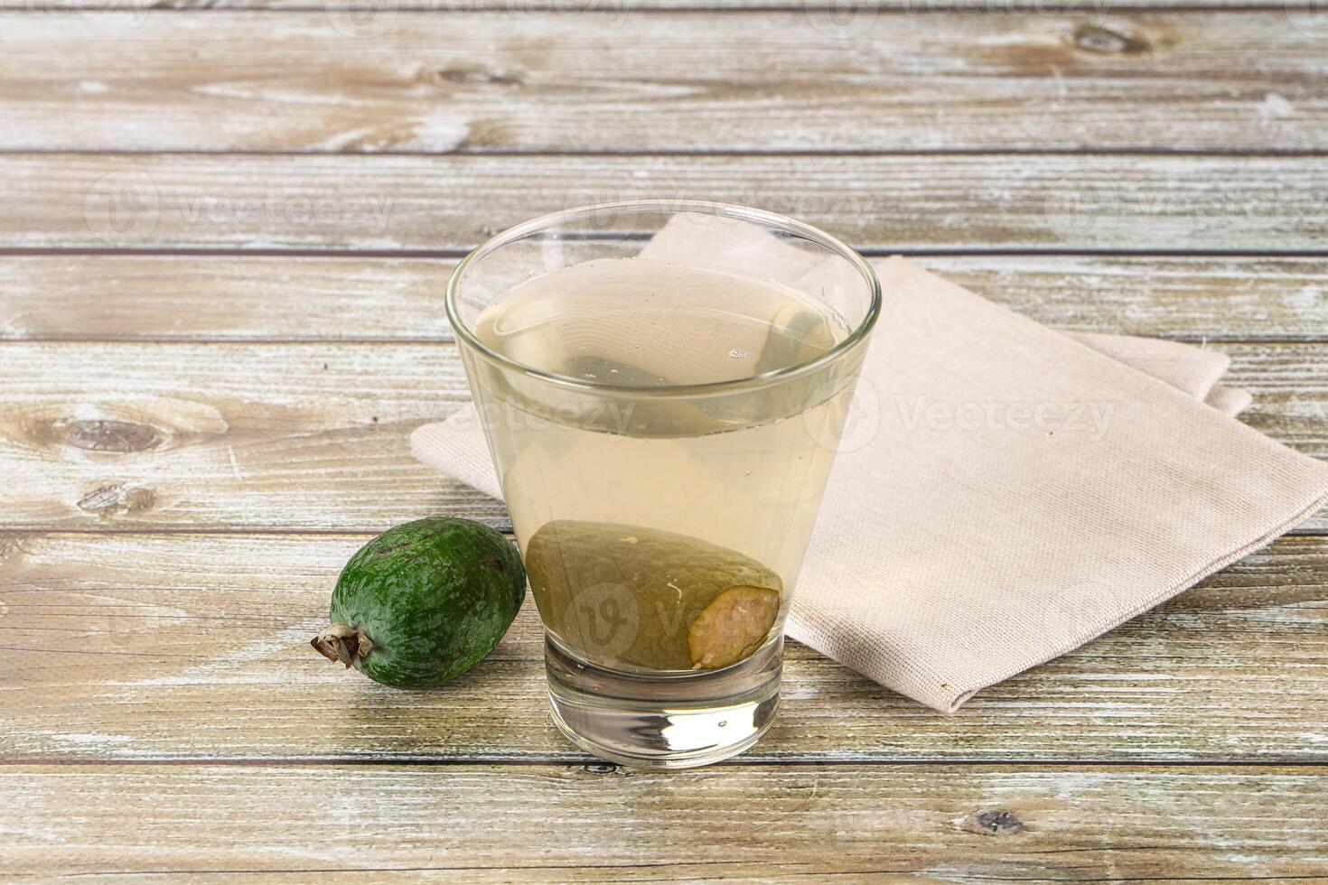 A glass of water and a green apple on a table photo