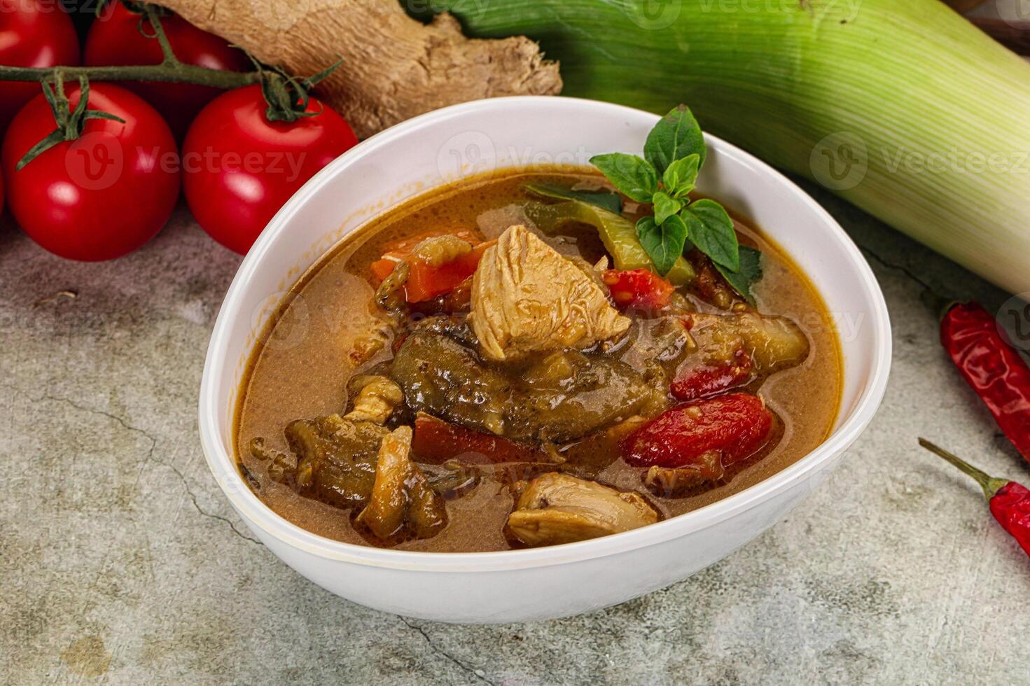 A bowl of curry with vegetables and spices photo