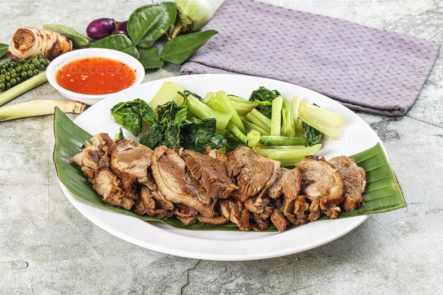 A plate of meat and vegetables on a table photo