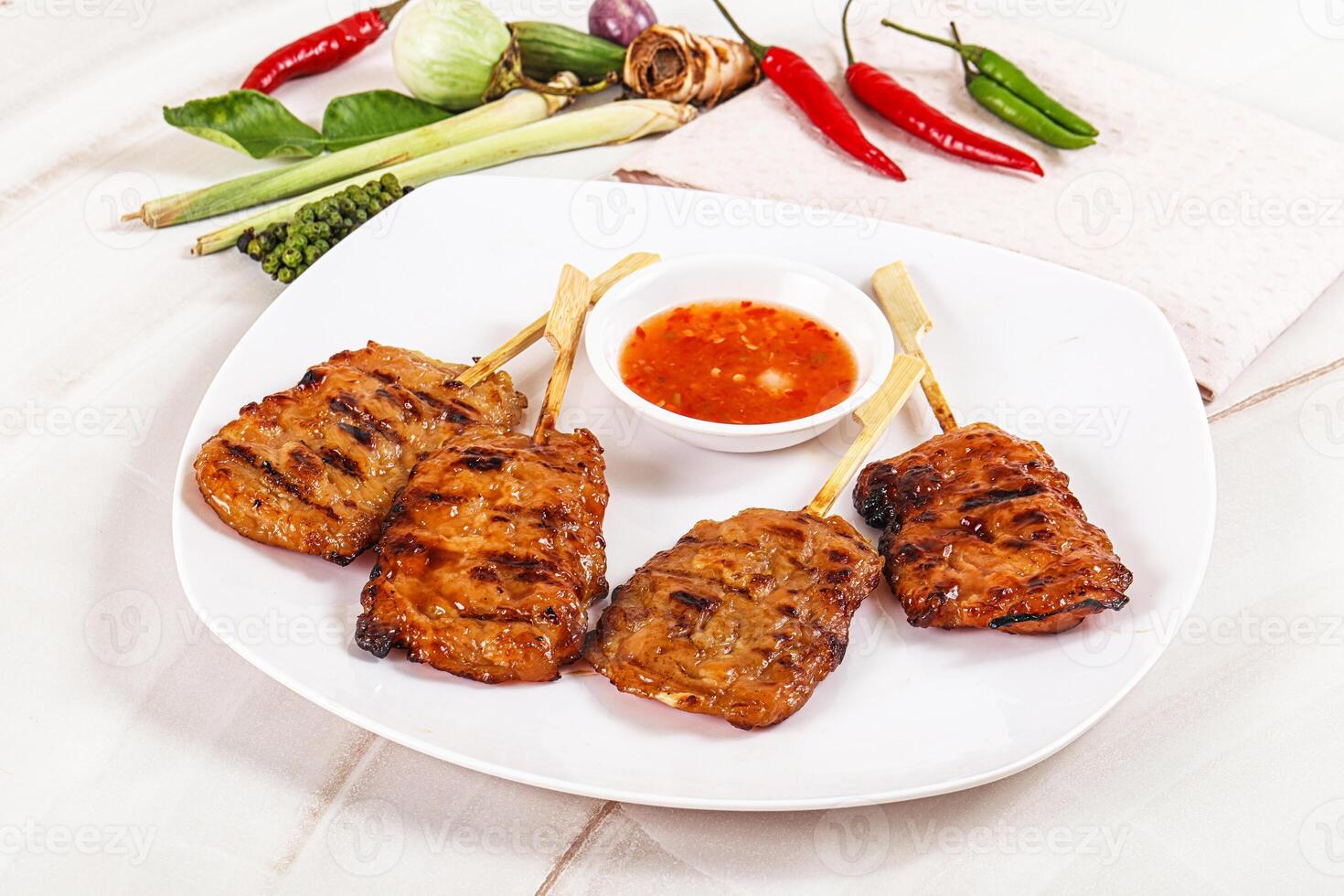 A plate of food with skewers and sauce photo
