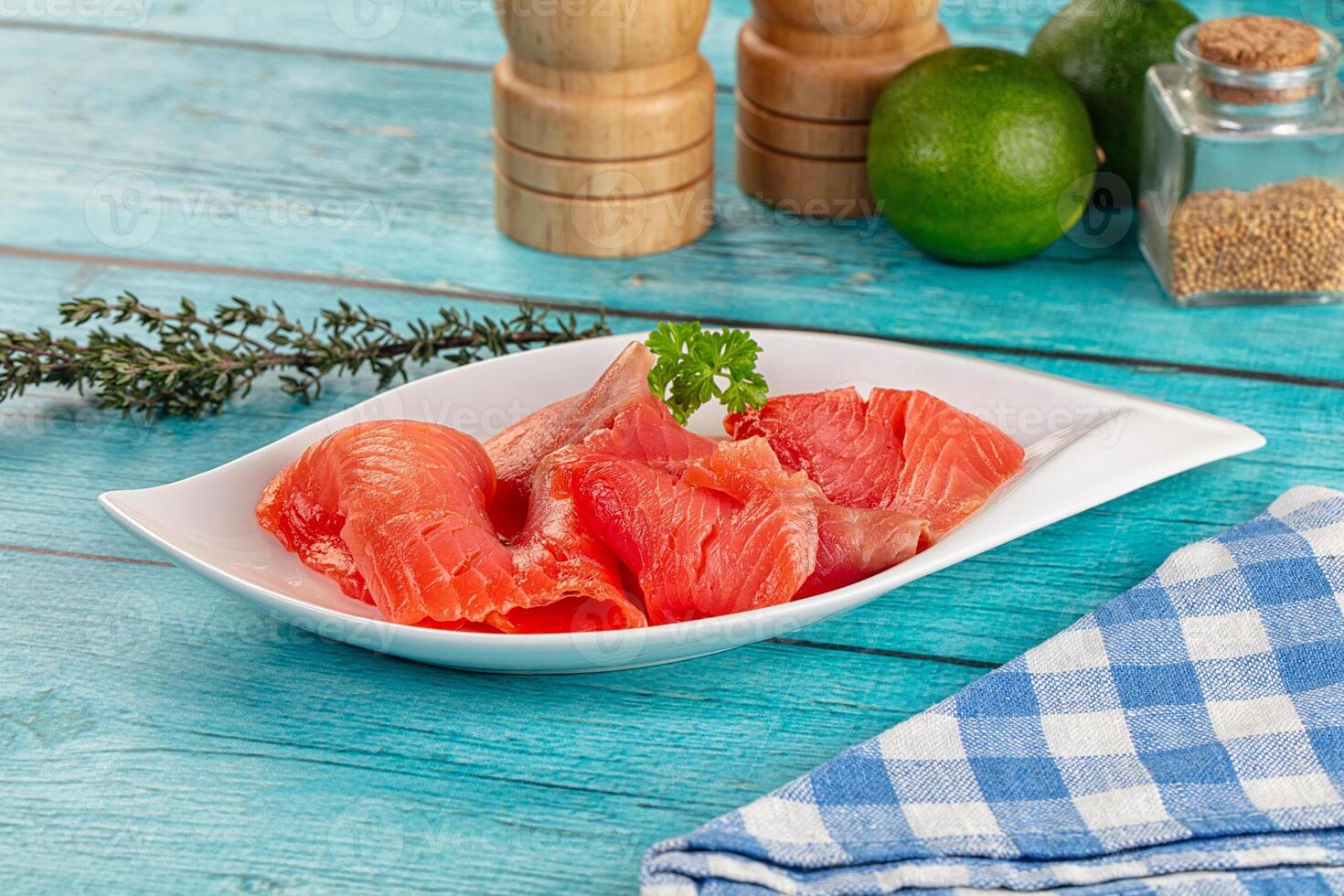 A plate of raw salmon on a blue table photo