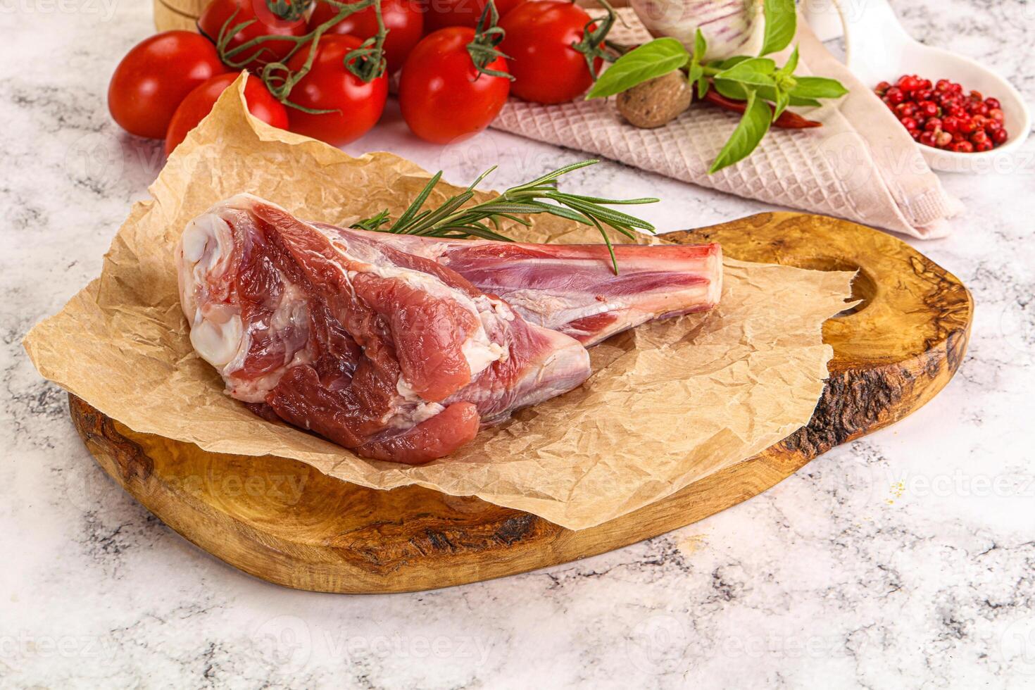 A piece of meat on a cutting board with tomatoes and herbs photo